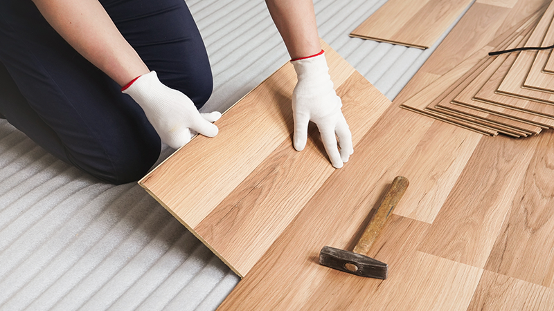 Photo d'un solier en train de poser du parquet flottant